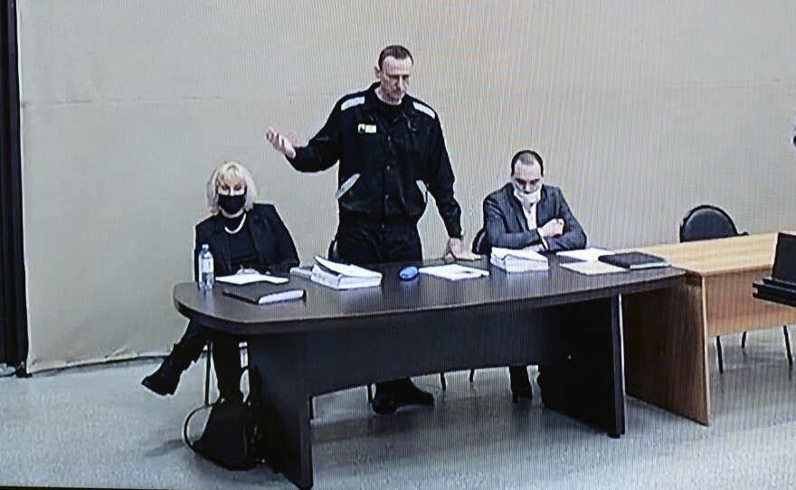 In this image provided by the Russian Federal Penitentiary Service, Russian opposition leader Alexei Navalny speaks via a video link, as he stands next to his lawyers during a court session in Pokrov, Vladimir region, about 62 miles east of Moscow, Russia, in January.