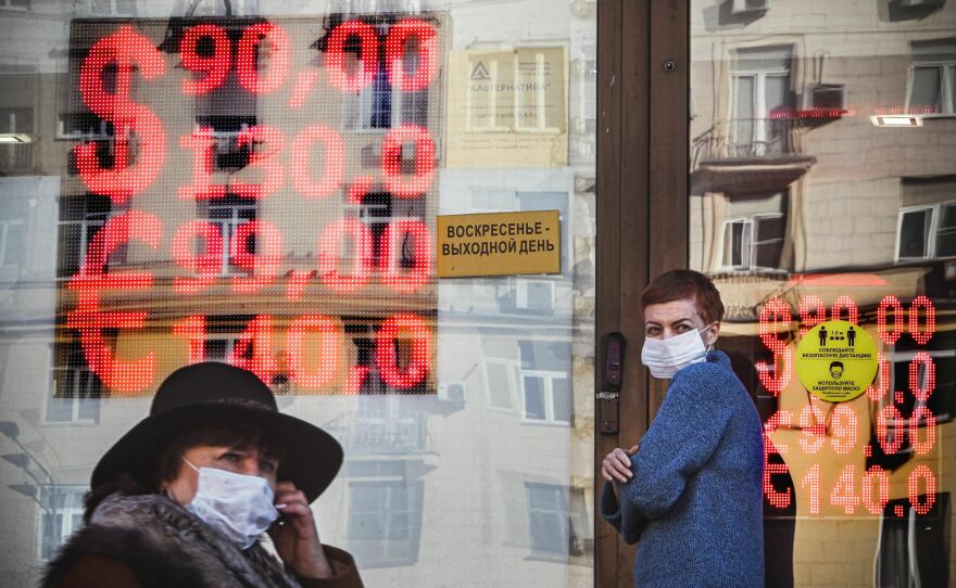People walk past a currency exchange office in central Moscow on Feb. 28. The Russian ruble collapsed against the dollar and the euro on the Moscow Stock Exchange on Feb. 28, as the West imposed harsh new sanctions over Russia's invasion of Ukraine.