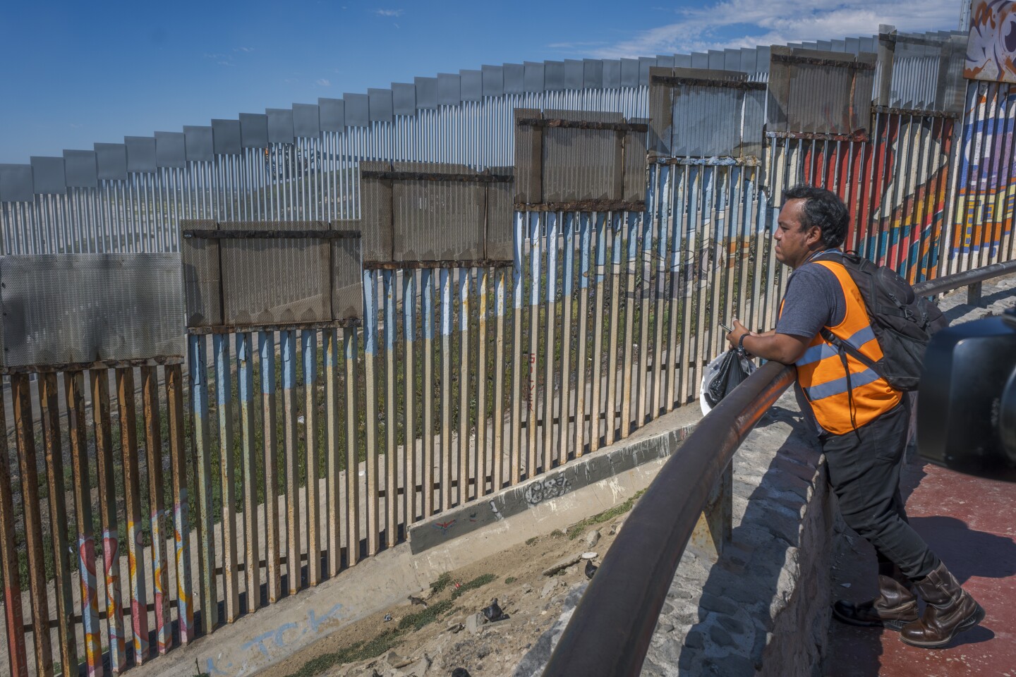 A Mexican worker stares at the American-built border wall from the Mexican beach community of Playas de Tijuana on Aug. 18, 2023.