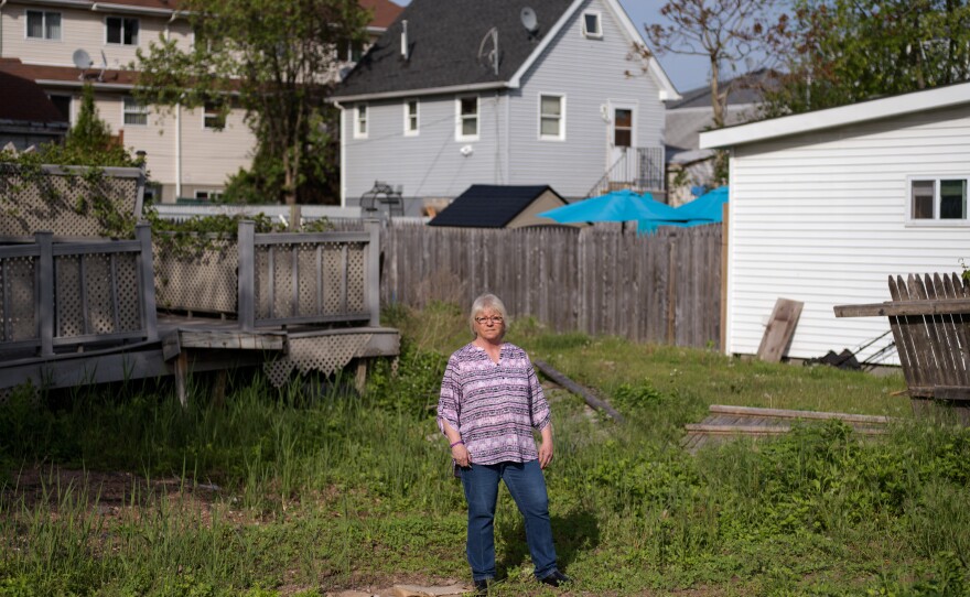 Like many other homeowners, Ann Marie Cianci — standing near her abandoned house on Staten Island, N.Y. — has been unable to move back home. After paying flood insurance for 32 years, she received only $60,000 out of her $250,000 policy.