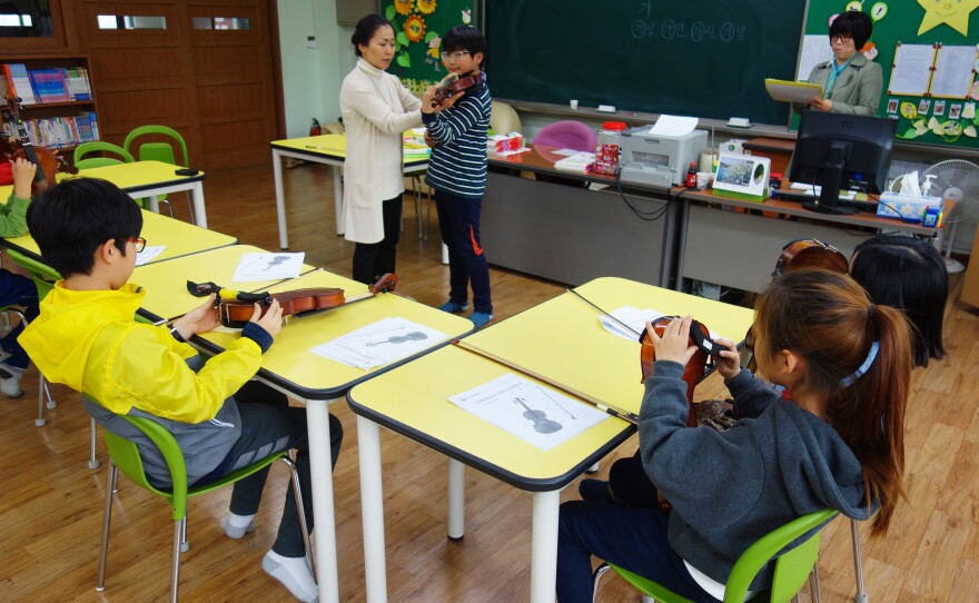 A violin lesson at Ansan West Elementary School, where students come from so many different countries that the school has a "multicultural coordinator" and language support for non-native Korean speakers.