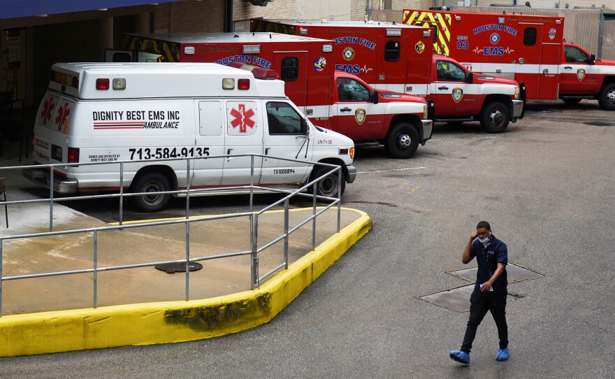 A medical worker walks past a row of ambulances parked outside Houston Methodist Hospital on June 22. The hospital is treating a current surge of COVID-19 cases.