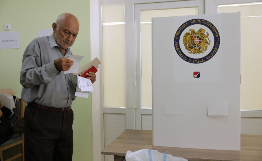 A man looks at his ballot at a polling station during the parliamentary election in Yerevan, Armenia, Sunday, June 7, 2026.