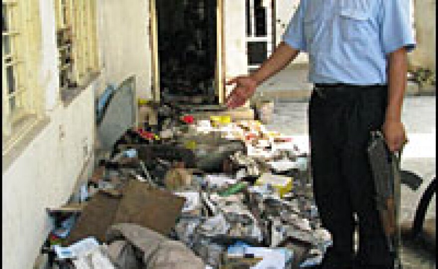 A Turkman guard shows debris from Kurdish protestors' attack on the Turkman Front political headquarters last month.