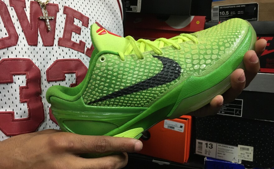 Davon Artis holds a pair of Kobe 6 Grinch shoes, released in 2010. The shoes more than doubled in value within hours of Bryant's death.