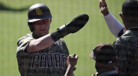 San Diego Padres' Jake Cronenworth is congratulated after scoring during the eighth inning of the team's baseball game against the Arizona Diamondbacks in San Diego, Sunday, July 26, 2020. 