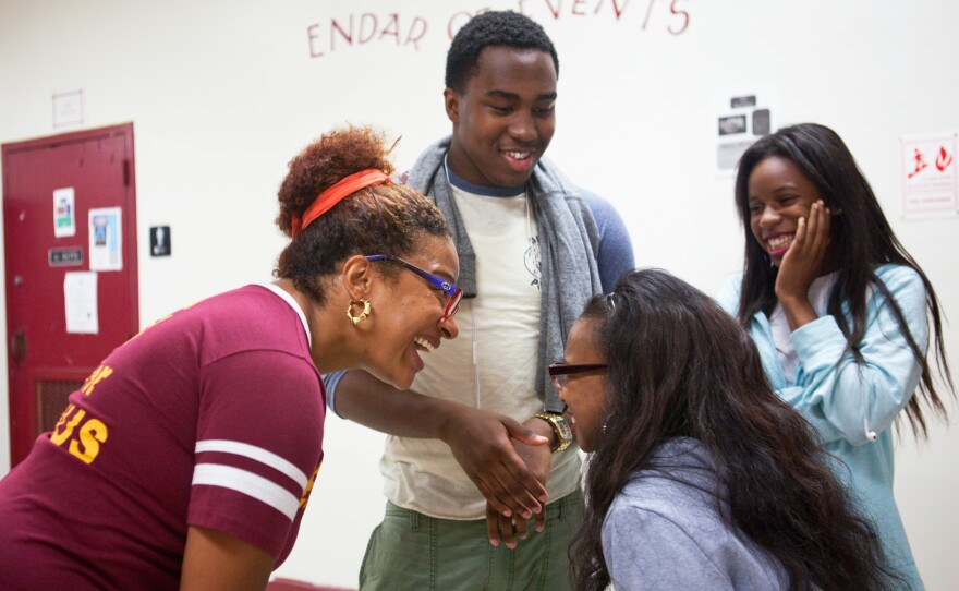 Principal Nikkia Rowe (left) exchanges laughs with students as they head to the cafeteria for lunch.