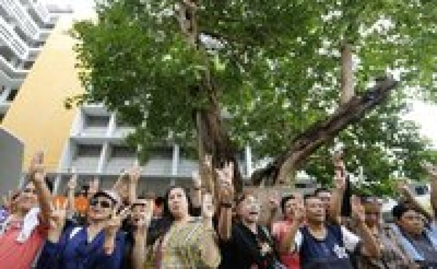Thai protesters demonstrate during an anti-coup rally at Thammasat University in Bangkok on Sunday. At least two protesters were arrested as thousands of soldiers and police were deployed in Bangkok to thwart sporadic protests against the May 22 coup.