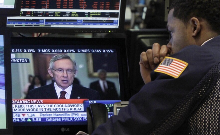 A specialist on the floor of the New York Stock Exchange watches Sen. Harry Reid talk on television Monday.