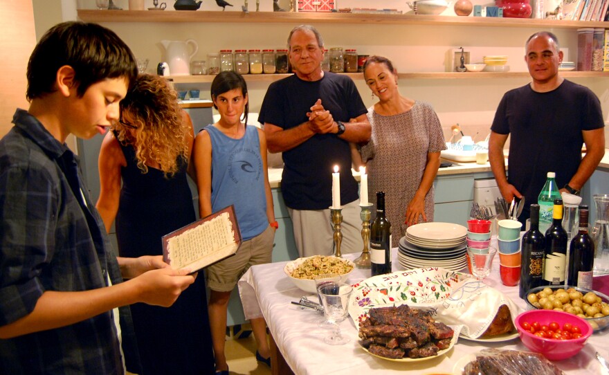 Calderon (center) looks on as her son reads the blessing before Friday night Shabbat dinner.