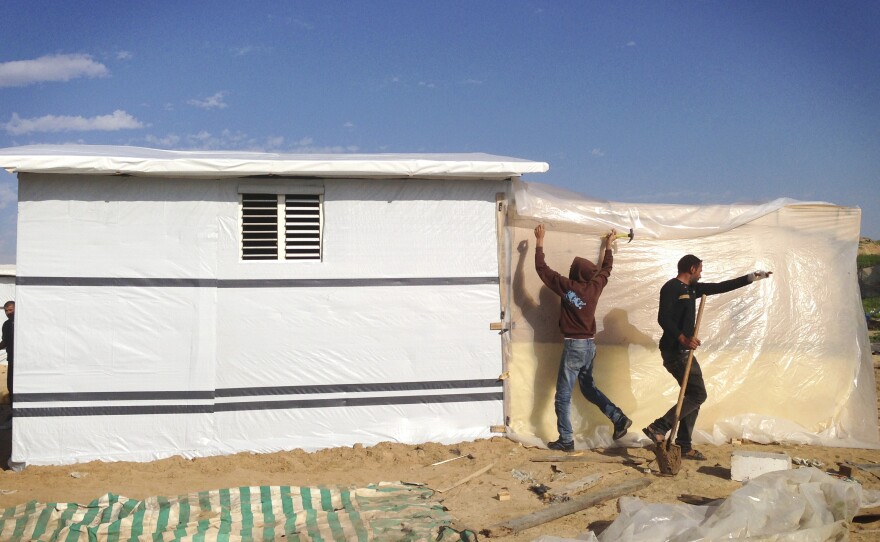 A group of Gazans construct wooden homes because of the difficulty obtaining cement.