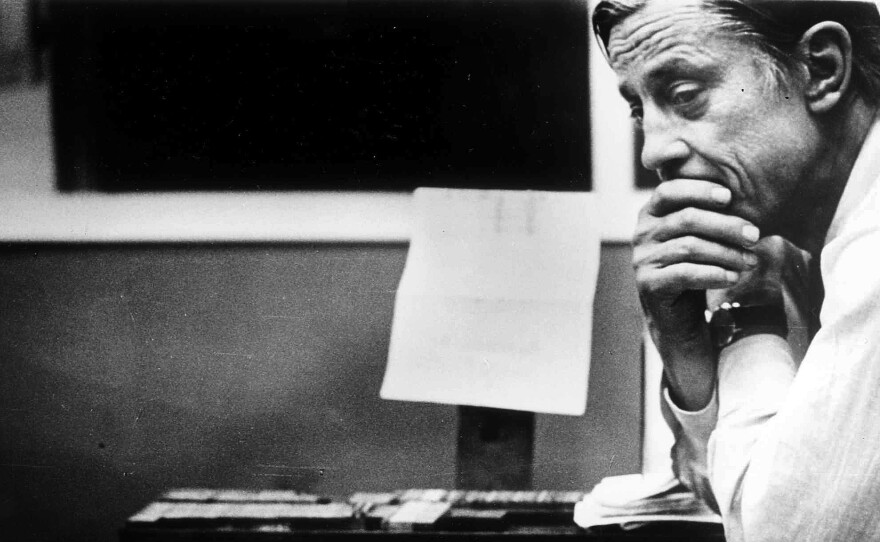 Ben Bradlee, then-executive editor of The Washington Post, looks at the front page of the newspaper, headlined "Nixon Resigns," in the composing room on Aug. 8, 1974.