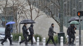 Pedestrians make their way along a street in the pouring rain in downtown Los Angeles on Wednesday, March 21, 2018.