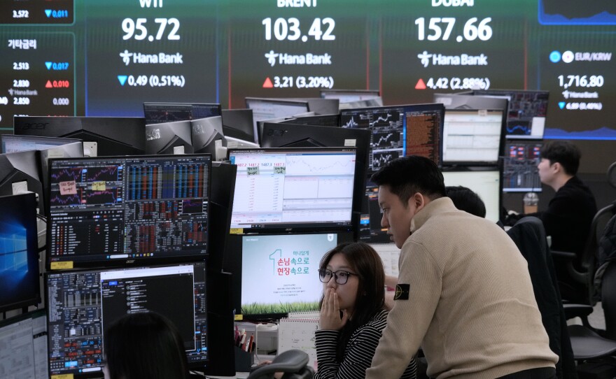 Currency traders watch monitors near a screen showing international oil prices at the foreign exchange dealing room of the Hana Bank headquarters in Seoul, South Korea, on March 18.