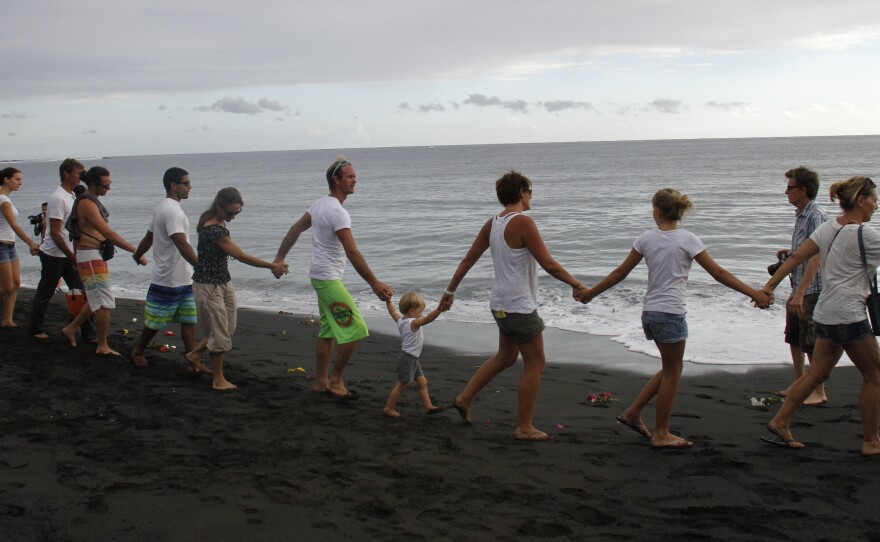 Mourners form a human chain along a beach on the French island of Reunion after Talon Bishop, 22, was killed by a shark in February.