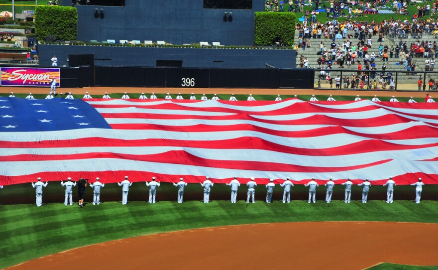 Sailors assigned to the aircraft carrier USS Carl Vinson unfurl the "Pacific Life Holiday Bowl Big Flag" during pre-game activities at PETCO Park to commemorate the ninth anniversary of the Sept. 11, 2001 terrorist attacks on New York and Washington.