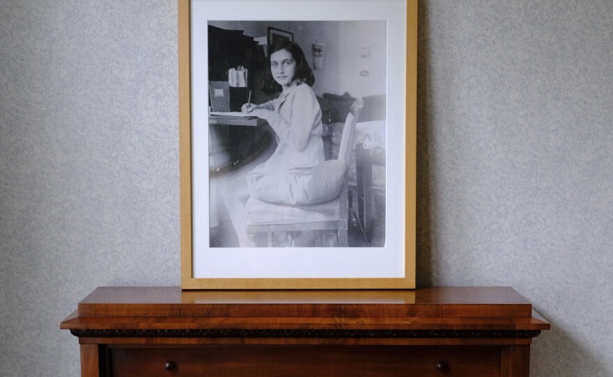A photo of Anne Frank stands on a replica of the writing desk she once used in her family's former apartment in Amsterdam, during an event to mark what would have been Anne Frank's 90th birthday, in Amsterdam in June 2019.
