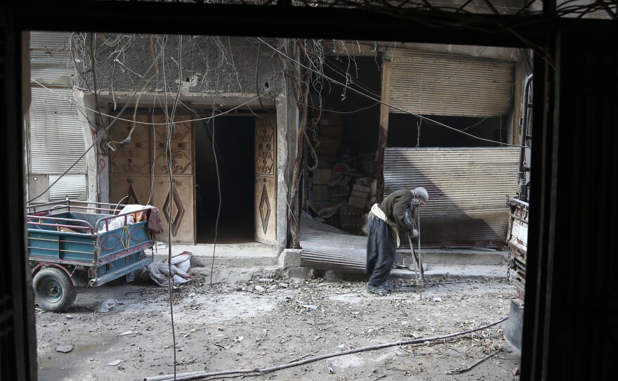 An elderly Syrian man searches for safe shelter Wednesday in the rebel-held town of Hamouria, in eastern Ghouta. The Syrian government bombarded the area before breaking through rebel lines Wednesday night. On Thursday, thousands of civilians fled the district via a protected corridor for civilians.