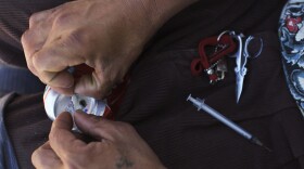 A drug addict prepares his fix of "speedball", a combination of heroin and crystal meth, at a street corner near the international border in Tijuana, Mexico, Aug. 25, 2009. 