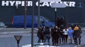 Security officers escort released hostages after they stormed a kosher market to end a hostage situation in Paris, Jan. 9, 2015.

