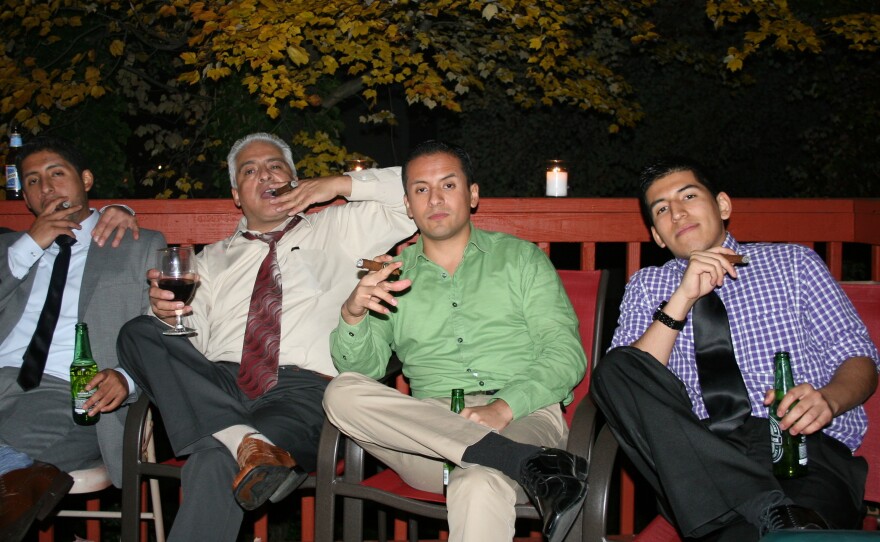 Victor Alarcon, Sr., smokes a cigar with his three sons Alvaro (left), Victor Jr., and Miguel. The elder Alarcon immigrated from Bolivia in the 1980s.
