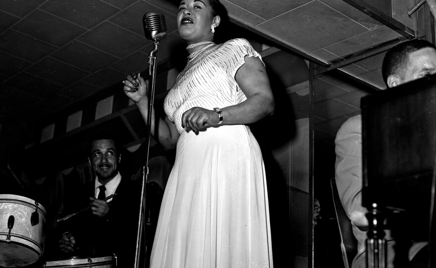 Billie Holiday singing with a band.