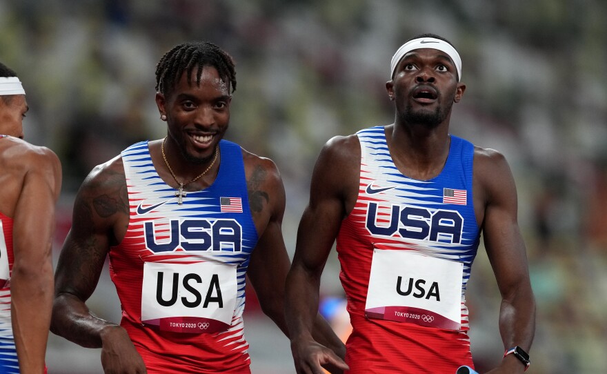 USA's Michael Cherry (left) and Rai Benjamin after winning gold in the men's 4 x 400 meter relay at the Olympic Stadium in Japan on Saturday.