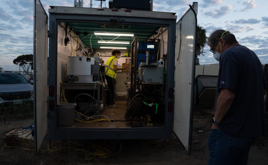 A researcher with Scripps Institution of Oceanography conducts her studies near the Tijuana River as Imperial Beach resident Tom Csanadi observes on Sept. 6, 2024.