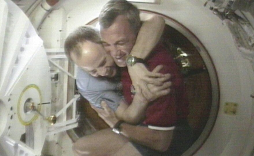 U.S. Space Shuttle Commander Terrence Wilcutt (right) and Mir Commander Anatoly Solovyev hug after opening the hatches between the space shuttle Endeavour and the Russian Space station Mir Saturday, Jan. 24, 1998, in this image from television