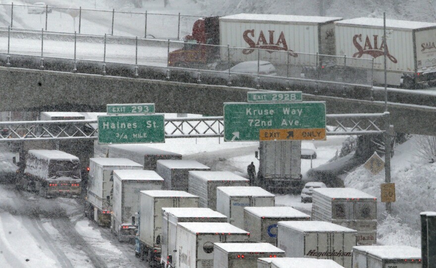 Early morning traffic backs up on Interstate 5 during a Jan. 11 snowstorm in Portland, Ore. Truck drivers say such conditions, combined with limitations on their working hours, cost them a lot of money because of their mileage-based pay.