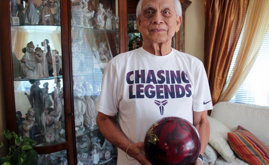 Alex Padua, who was an avid bowler at Naval Support Activity Bethesda, poses with his bowling ball at his home in Wheaton, Md.