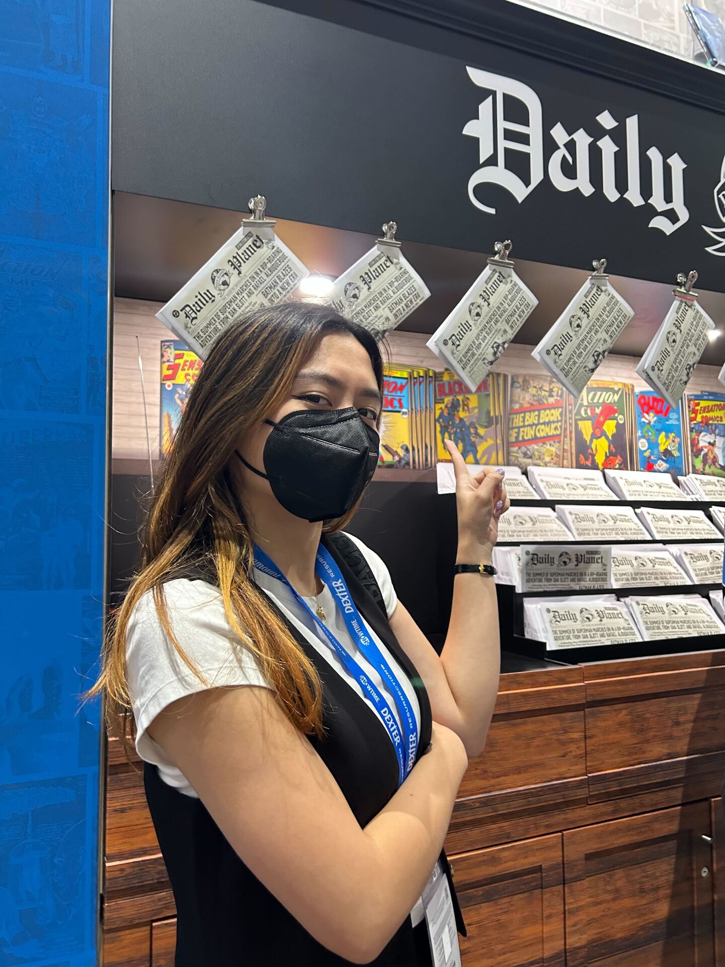KPBS Midday Edition producer Julianna Domingo cosplays as Lois Laine from James Gunn's "Superman," posing in front of the movie's Daily Planet-themed booth at Comic-<br/>Con on July 25, 2025.