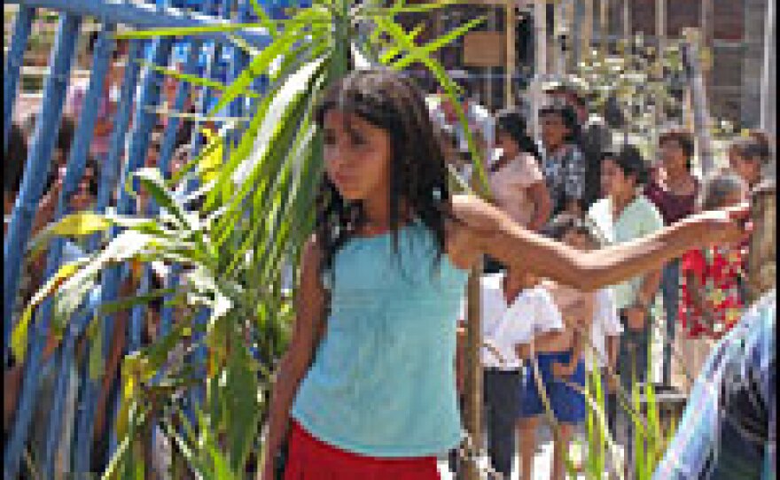 A girl waits as a church group passes out blankets and clothes at the Gerardo Barrios squatter camp. Residents say they built shacks here over the past year because they could no longer afford to pay rent and cover their other living expenses.