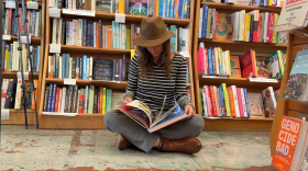 Britton Neubacher pages through a copy of "Plenty For All: The Art of Rick Fröberg," at The Book Catapult on Jan. 12, 2026.