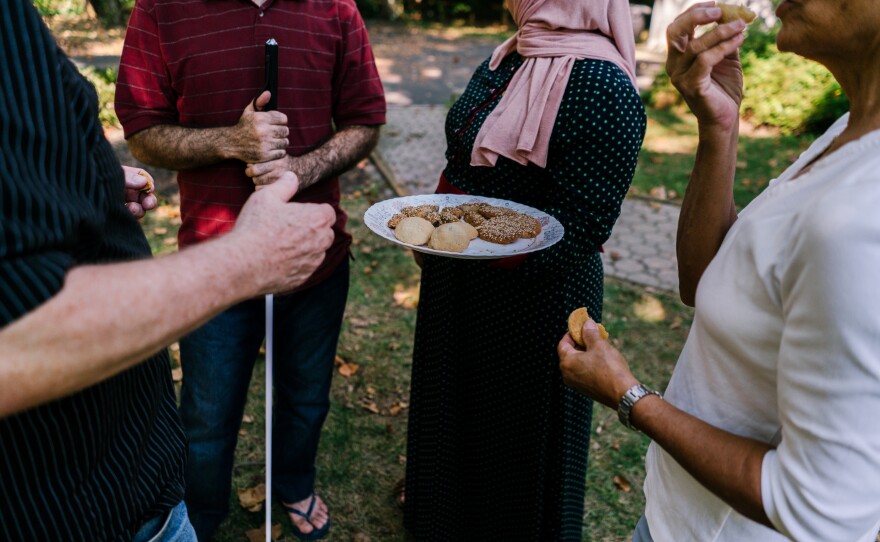 Ghada offers a tray of cookies she made to her husband Osama and Sue Jennings and Tom Charles, the two volunteers from the Nassau Presbyterian Church.