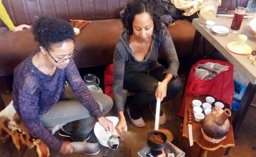 Luwam Melake (left), a recently arrived Eritrean refugee, and Saba Tesfay, who is half-Hungarian and half-Eritrean, wash, roast and grind coffee beans during a traditional Eritrean coffee ceremony. They performed the ceremony at the Kisuzem restaurant as part of a Budapest food festival celebrating the cuisine from Syria, Afghanistan, Eritrea and Somalia.