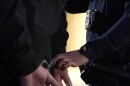 A police officer placing handcuffs on a person in this undated image released by San Diego Police Department.
