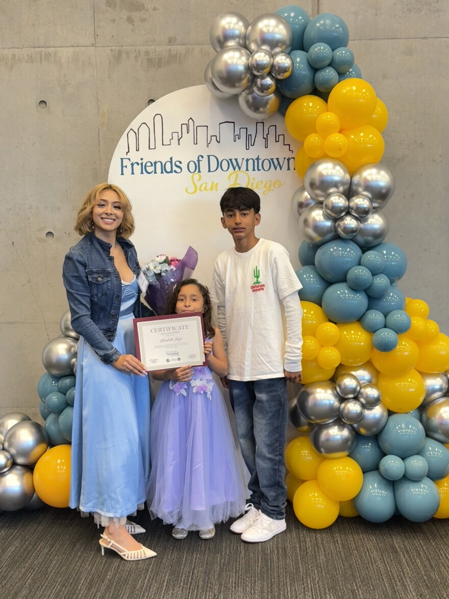 City College student Elizabeth Lugo stands with her children, 9-year-ld Aaliyah and 13-year-old Felipe, after receiving a scholarship award from Friends of Downtown San Diego.