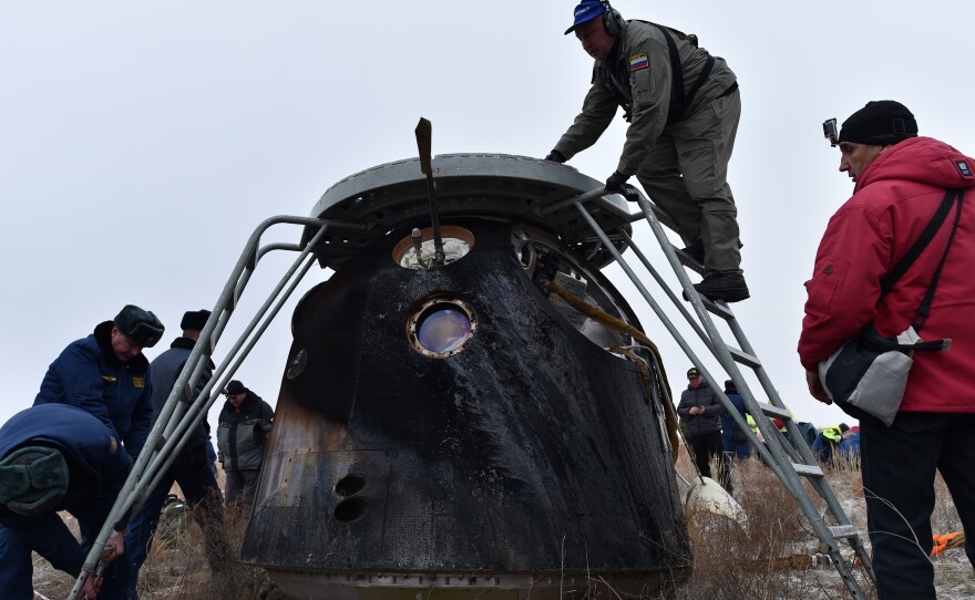 A search and rescue team works at the site where the capsule landed.