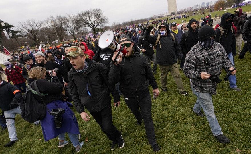 Prosecutors say Ethan Nordean, seen with a bullhorn, led members of the far-right group the Proud Boys in the Jan. 6 riot. He faces federal charges, but will be released from custody while he awaits trial.