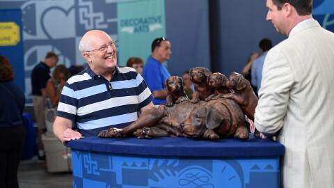 Matthew Quinn (right) appraises Walter Mader black forest carved dogs, ca. 1900, in Charleston, SC. 