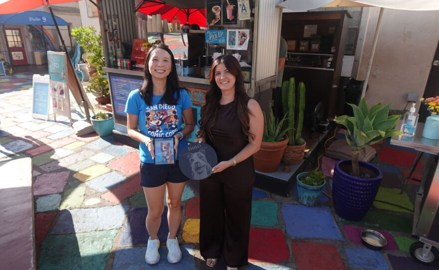 Amanda Moschella, right, and Winnie Leung, left, hold photos of their late dogs outside Daniel’s Coffee at Spanish Village Art Center on Sept. 14, 2026.