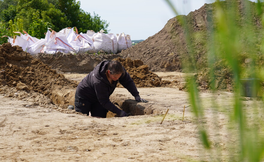 An archaeologist excavates a Viking Age pit house in Aarhus, Denmark, on June 22, 2026.
