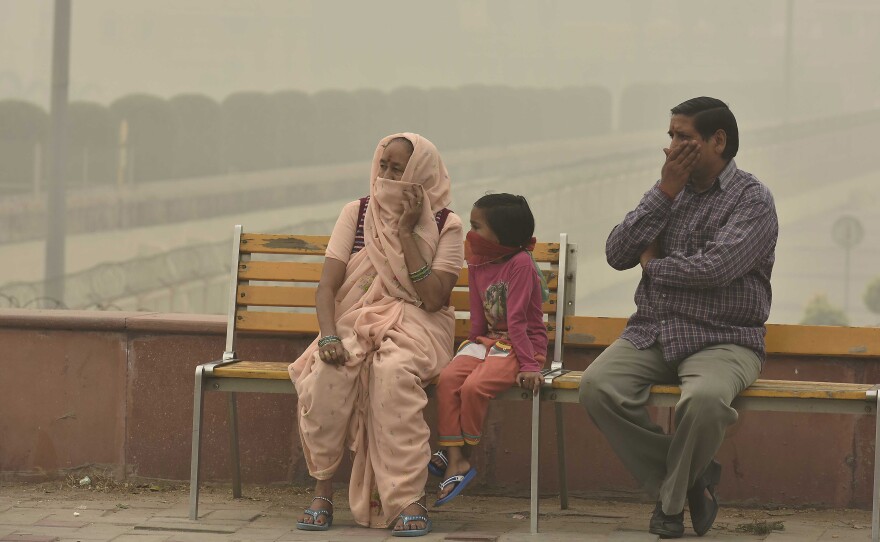 People cover their faces with masks to avoid thick smog in New Delhi on Nov. 5. People living there have complained about respiratory problems.