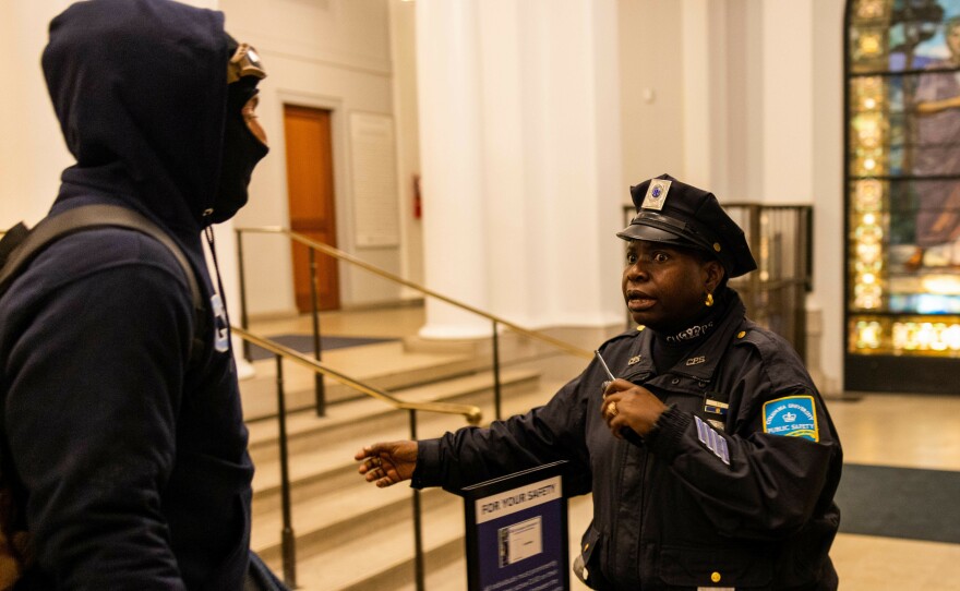 A Columbia University police officer reacts as multiple demonstrators enter Hamilton Hall in the early hours of Tuesday. The protesters proceeded to barricade themselves inside the academic building.