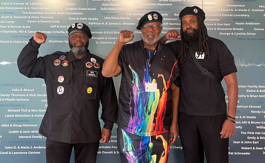 Black Panther Party field marshal Yusef Miller (left), San Diego Original Black Panther Party for Community Empowerment chairman Henry Wallace and Black Panther Party chief of staff Koran Cameron (right) stand in KPBS, Oct. 12, 2026.