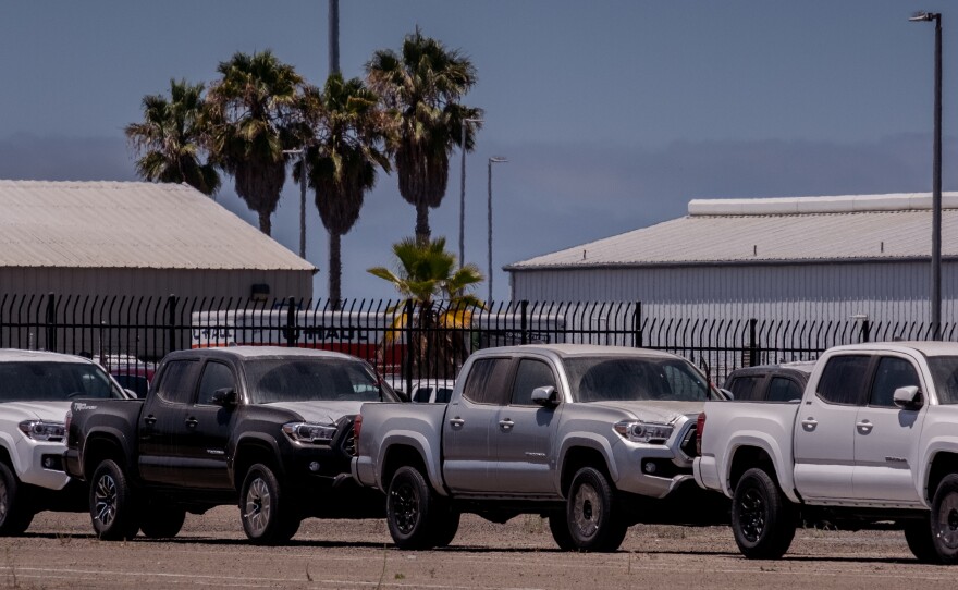 Dust collects on hundreds of new Toyota Tacoma trucks sit in one of many storage lots in National City waiting to be shipped to new car dealers, July 27, 2022.