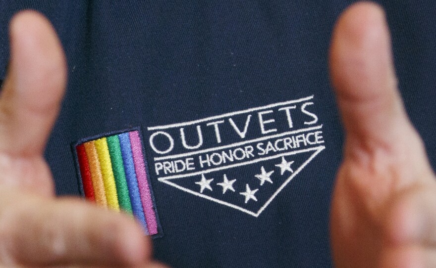 OutVets founder Bryan Bishop wears the logo of his group while speaking in Boston. The group has been invited to participate in the city's privately-run St. Patrick's Day parade.