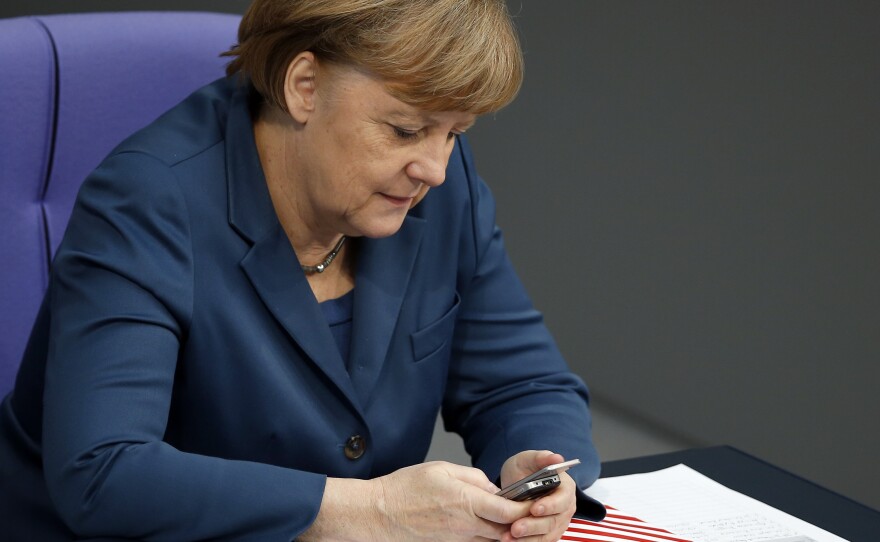 German Chancellor Angela Merkel uses a mobile phone during a meeting of the German federal parliament in Berlin, on Nov. 28, 2013. The country's labor minister supports a call that would prohibit employers from sending emails to employees after normal business hours.