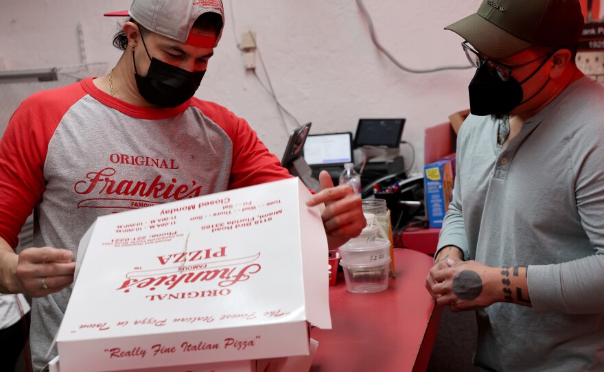 A worker rings up an order at Frankie's Pizza on Jan. 12 in Miami, Fl. The labor market is getting healthier, but much will depend on the progress of the pandemic, which can easily sway demand for workers — especially at businesses that rely on in-person contact with customers.